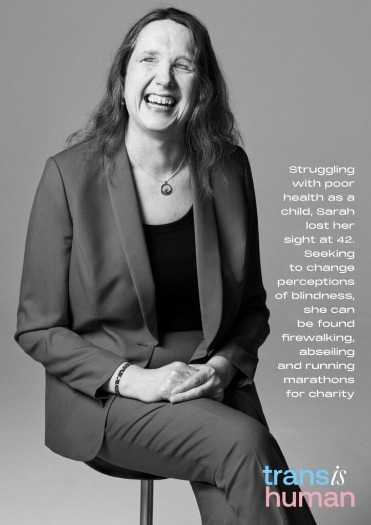 Black and white photo of Sarah in a suit, joyfully smiling while seated. Text on right details her achievements and advocacy. "Trans is Human" logo below.