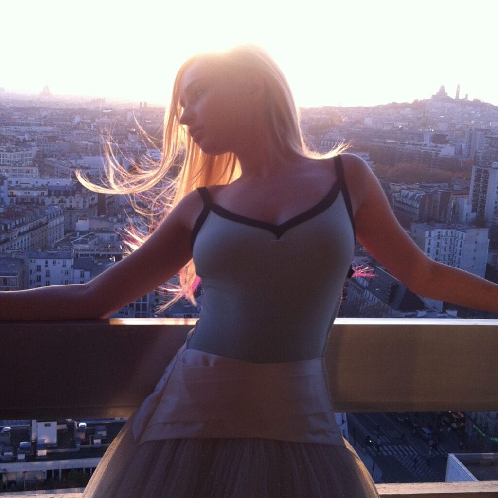 Official single cover artwork for "Jeep" which shows Kim Petras in a light top and skirt standing on a balcony at sunset. Her hair is softly lit, cityscape in the background. The mood is serene and reflective.